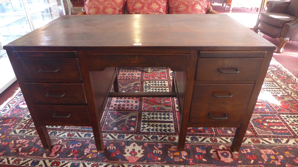 A Mid 20th century oak desk, frieze drawer flanked by an arrangement of three drawers to each side,