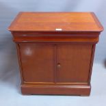 A biediermier style mahogany side cabinet with single drawer above two cupboard doors raised on