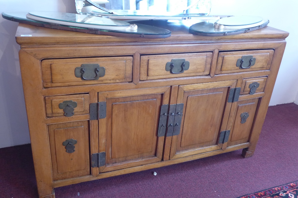 A 20th Century Chinese elm side board with an arrangement of five drawers and two cupboard doors.