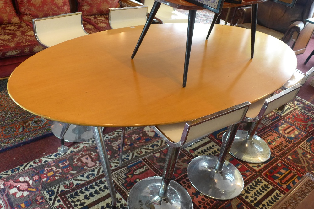 An Eames four Vitra oval table with beechwood top raised on chrome supports.
