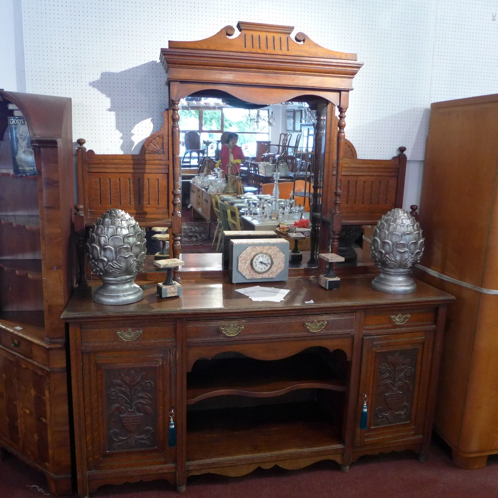 A Victorian oak mirrored back sideboard with three drawers above two carved cupboard doors and