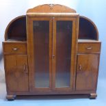An art deco burr walnut display cabinet with two glazed doors flanked by two drawers and two