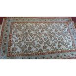 A Qum rug, traditional floral & bird design over cream ground, within pale blue & red borders.