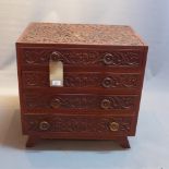 A 20th Century continental teak cutlery chest profusely carved with peacocks and floral motifs.