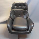 A Swedish black leather swivel chair raised on teak and chrome base.
