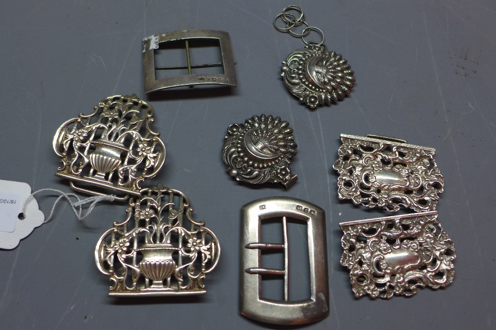 Three Victorian silver belt buckles together with a Persian white metal belt buckle