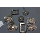 Three Victorian silver belt buckles together with a Persian white metal belt buckle