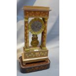 An early 20th Century Portico clock with marquetry inlay and raised on curb base.
