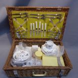 A 1950's picnic set in wicket basket.