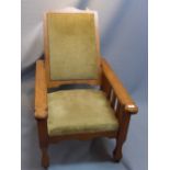 An arts and crafts oak reclining arm chair raised on tapered legs, spade feet and castors.