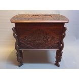 A 20th Century continental teak ottoman profusely carved with floral motifs,