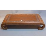 A 20th Century Chinese hardwood coffee table with floral carving and raised on scroll legs.