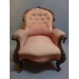 A Victorian rosewood spoon back armchair with button back upholstery raised on carved cabriole legs