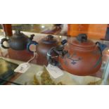 Three Chinese terracotta teapots in graduated sizes,