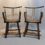 A pair of contemporary rustic oak elbow chairs.