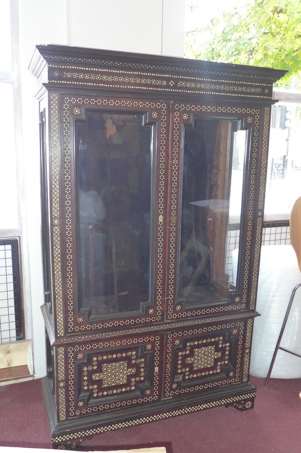 Early 20th century Moroccan bone inlaid cabinet, two glazed doors, fitted shelf interior,