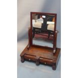 A large Victorian mahogany toilet mirror with two drawers and raised on bun feet.