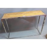 A contemporary console table with teak top, raised on chrome base.