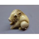 A Japanese ivory netsuke in the form of a boar, signed. L.3.