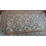 A Qum rug, traditional floral & bird design over cream ground, within pale blue & red borders.