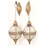 A pair of globular lanterns on brackets with gilt metal and glass