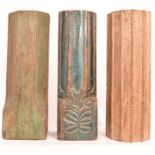 Three Indian temple hardwood candle stands, in various colours