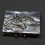 A white metal note case, embossed with two horse heads.