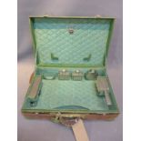 A 1920's green leather vanity case with chrome plated dressing set