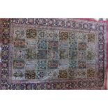 A Persian silk red ground rug, signed,