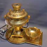 A gold coloured samovar with tray and bowl,