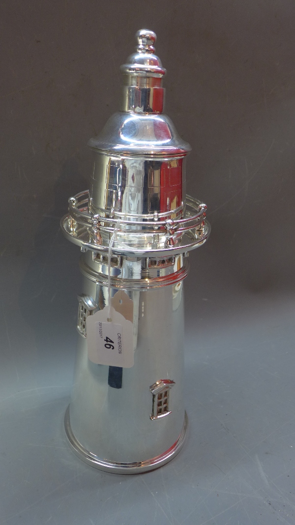 A silver plated cocktail shaker in the form of a lighthouse,