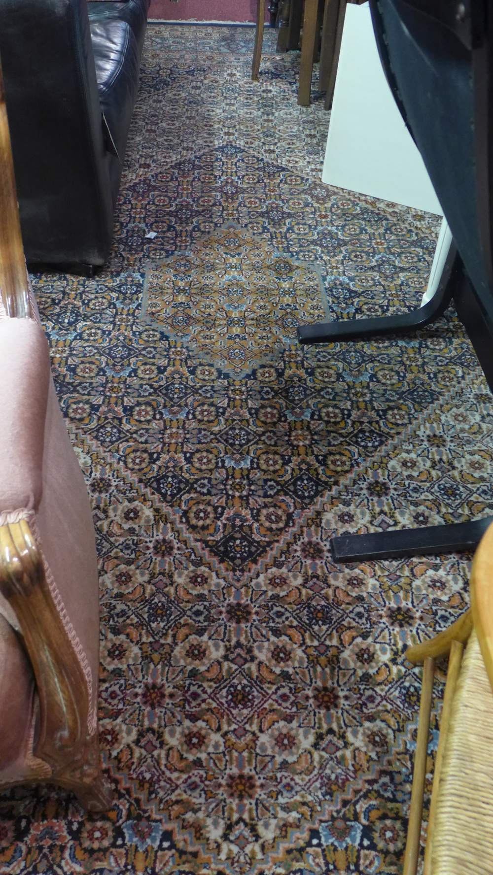 A fine Keshan carpet with double diamond floral medallion contained by navy borders,