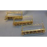 A set of three gilt metal coat hook shelves with mirrored tops