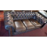 A three seater brown leather Chesterfield sofa.