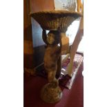 A lead bird bath in the form of a putti holding up a scalloped dish. H-75cm.