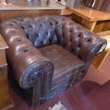 A brown leather Chesterfield arm chair.