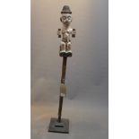 A white painted tribal figure on stand