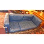 A Le Corbusier style Cassina three seater sofa with blue leather cushions and chrome supports.