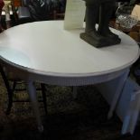 A Laura Ashley cream painted dining table, raised on tapered legs having two extra leaves.