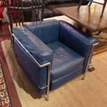 A pair of Le Corbusier style Cassina arm chairs with blue leather cushions and chrome supports.