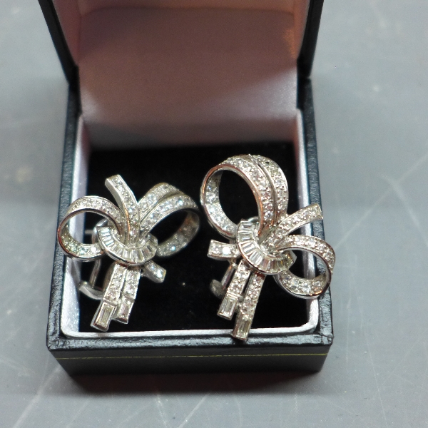 A pair of 1950's 18ct white gold and diamond earring of bow design.