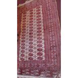 A Bokhara rug with eliphant pad motifs on a red and cream ground contained by borders,