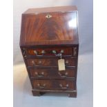 A 20th Century mahogany bureau with drop down flap over four graduating drawers raised on carved