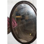 AN OVAL WOODEN FRAMED WALL MIRROR