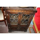 AN OAK LEADED GLASS BOOKCASE