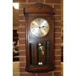 AN EDWARDIAN OAK WALL CLOCK