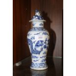 AN ORIENTAL BLUE AND WHITE VASE, featuring two mythical dragons meeting head to head, four character