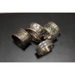 FOUR NAPKIN RINGS TO INCLUDE HALLMARKED SILVER EXAMPLES