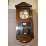 A SMALL OAK EDWARDIAN WALLCLOCK WITH PENDULUM AND KEY