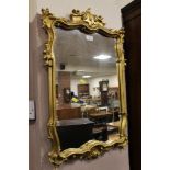 A GILT SHAPED WALL MIRROR